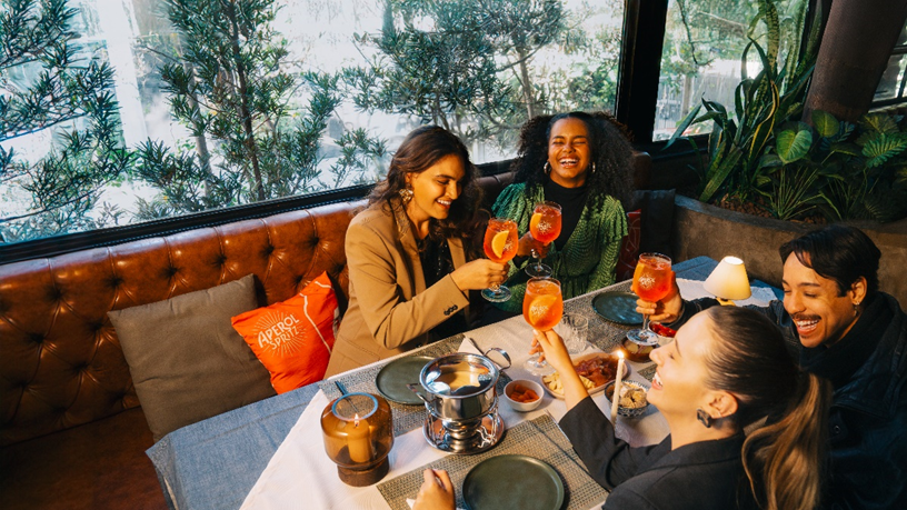 Amigos curtindo em um bar com Aperol Spritz